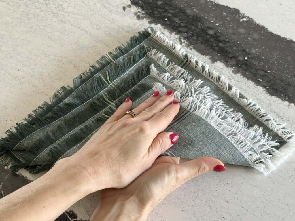 Flipping folded cloth napkin over.
