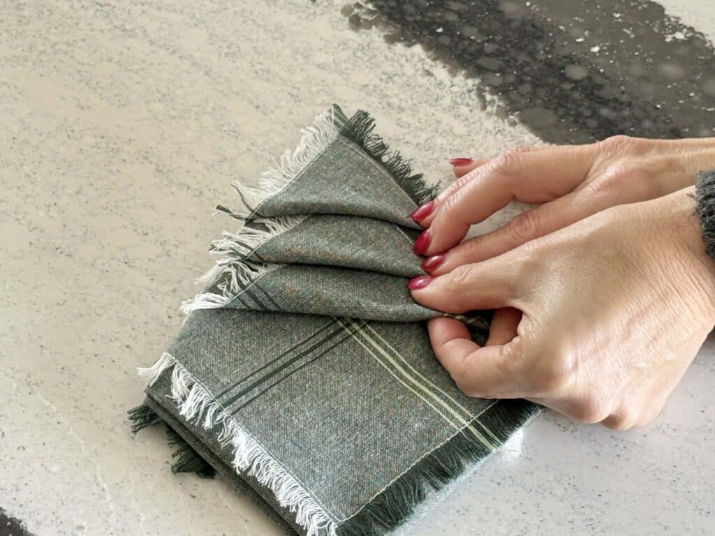 Tucking fabric napkin tips into cloth fold.
