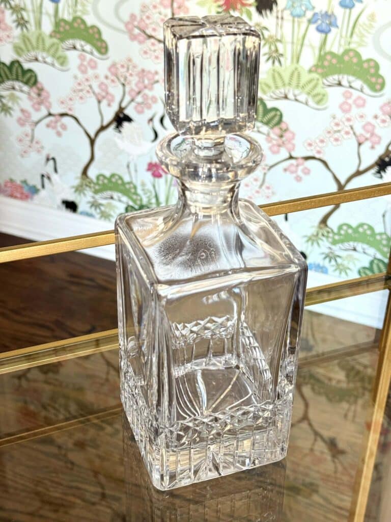 A cut glass decanter on a bar cart.