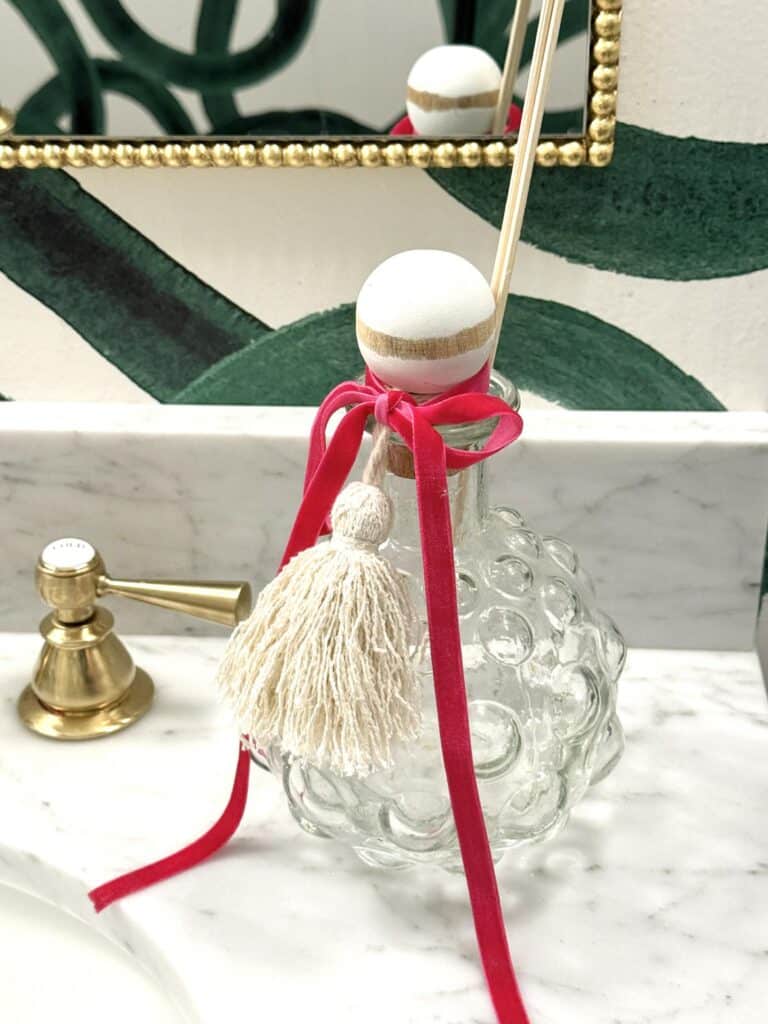 What to Put in a Decanter: A buble glass decanter used as a reed diffusser in a bathroom.