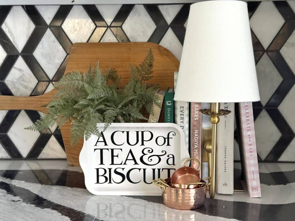 A lamps and cookbooks displayed on a kitchen counter.
