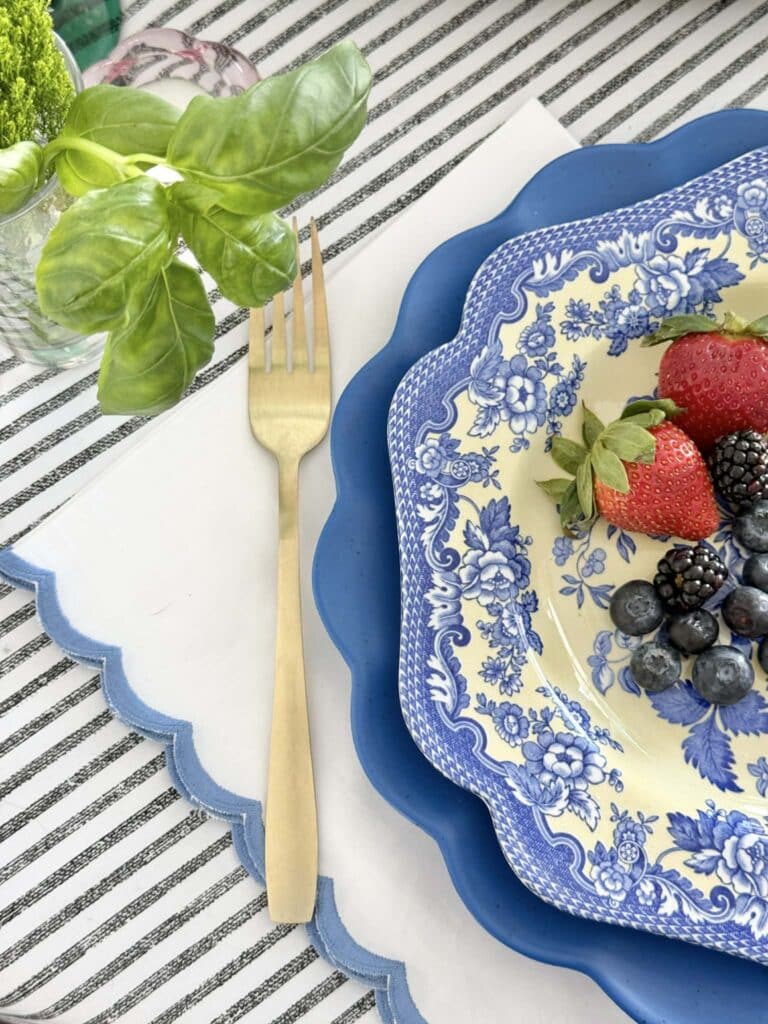 A table place setting on top of a black and white stripe bedspread.