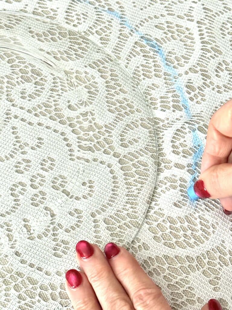 Drawing a chalkline around the perimeter of a glass plate.
