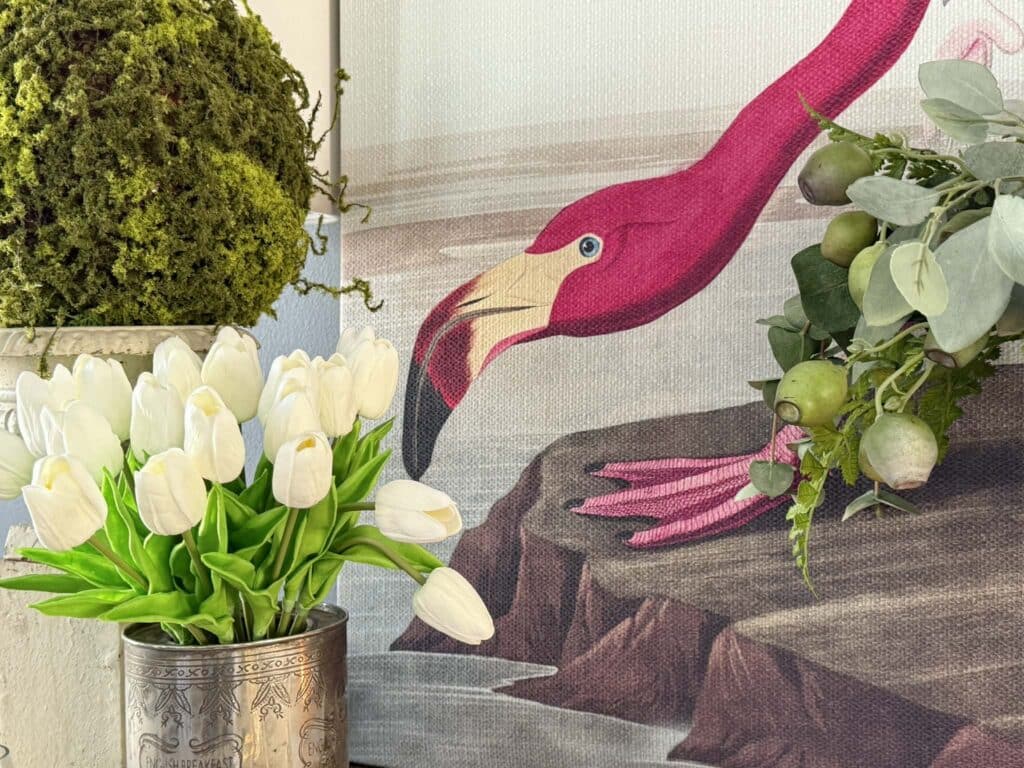 Bird artwork and white tulips in a design vignette.