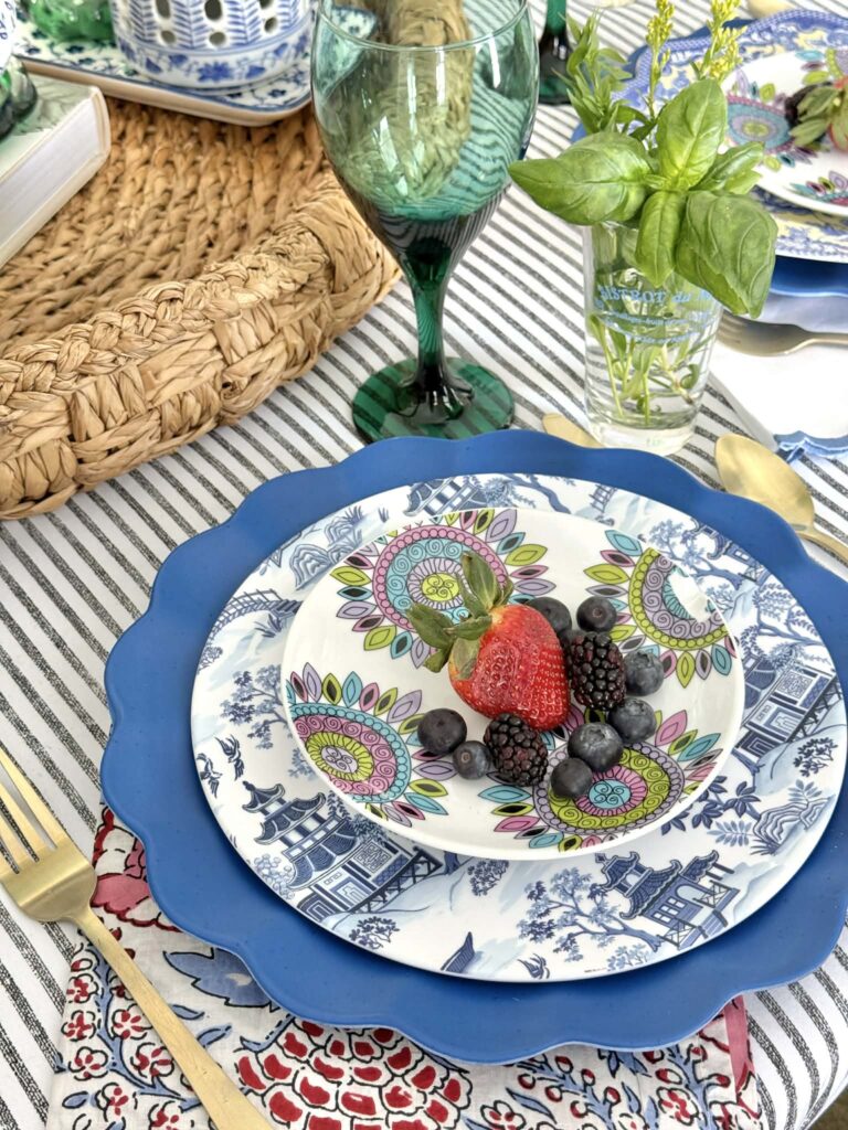 A spring table setting with layered plates topped with berries.