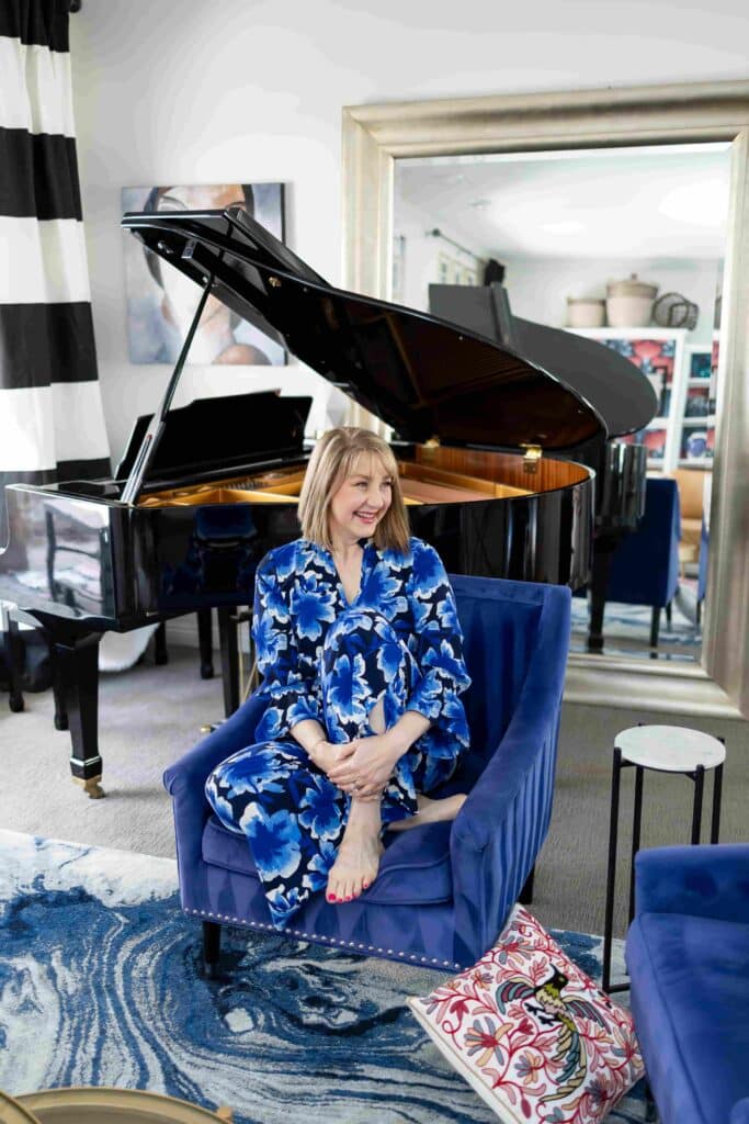 A woman dressed in blue and white sitting on a blue chair.
