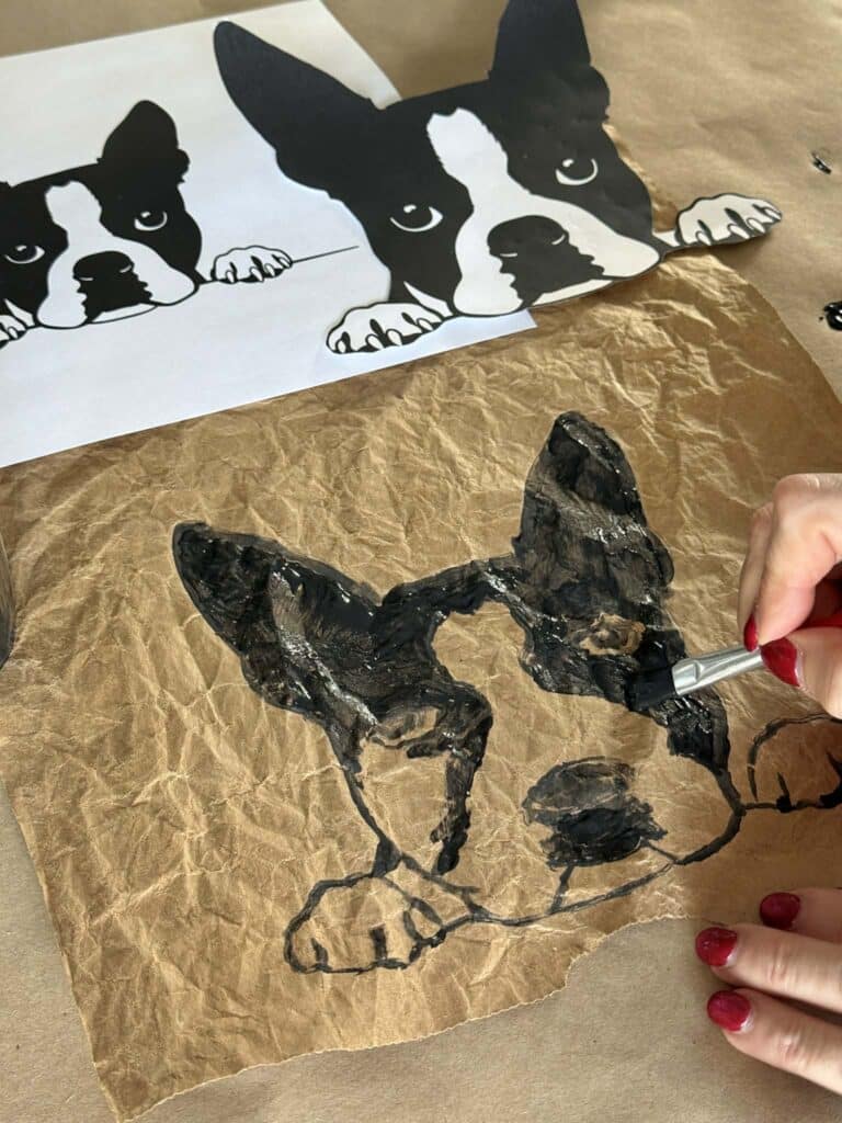 Painting a dog onto a grocery sack for paper bag art.