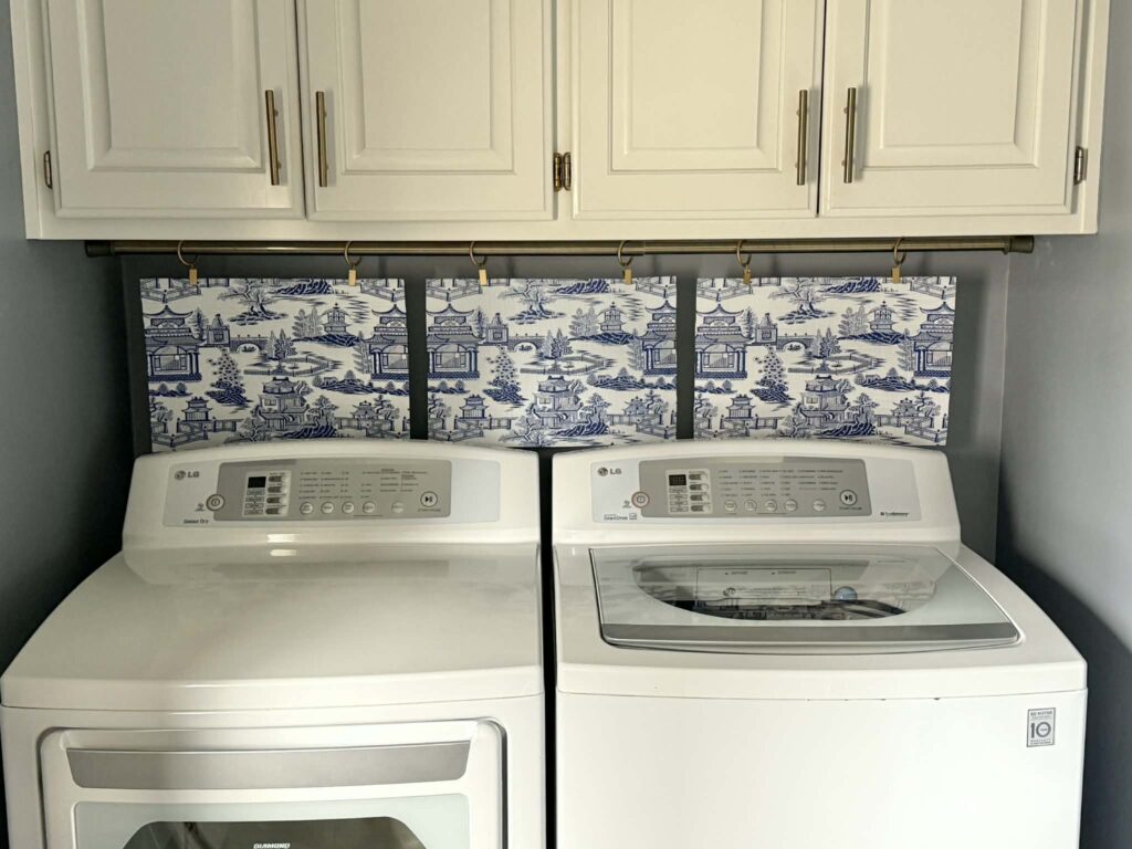 A placemat curtain hiding the outlets and washer dryer hookups in a laundry room.