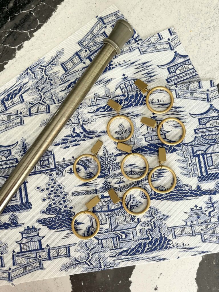 Three placemats, tension rod, and round curtain rings.