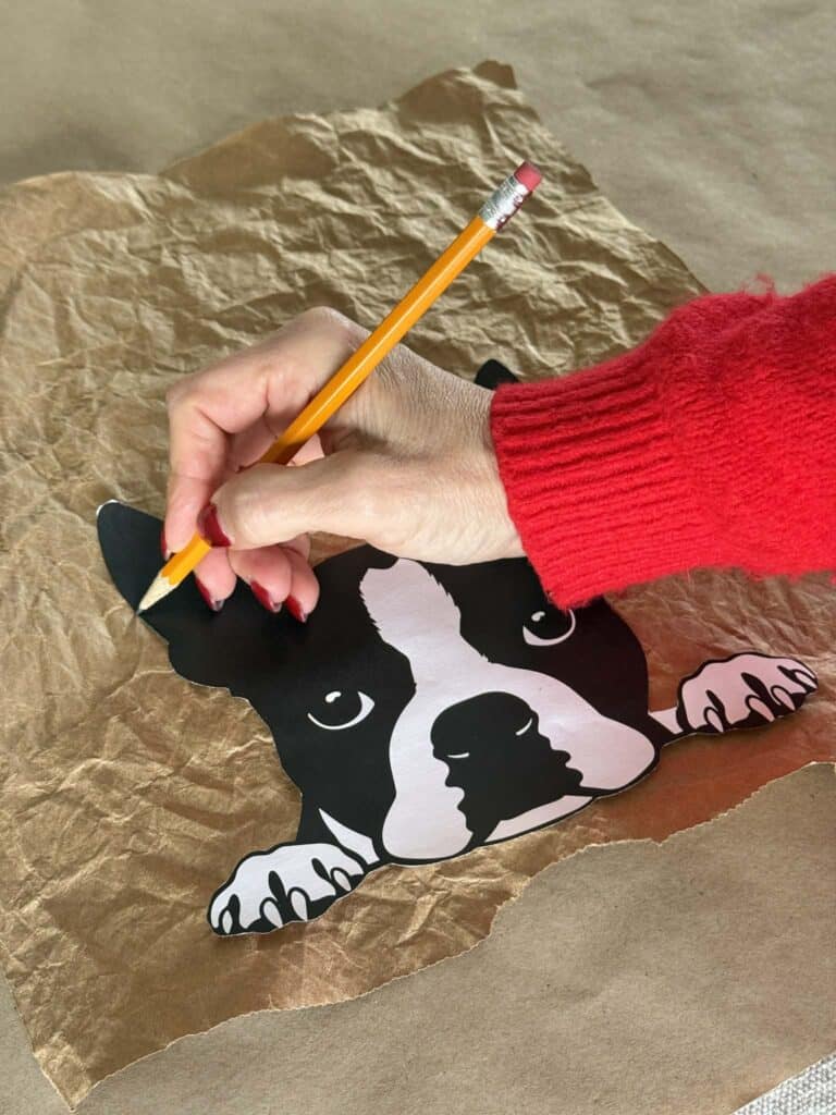 Tracing around a dog head image onto a paper bag for an art project.