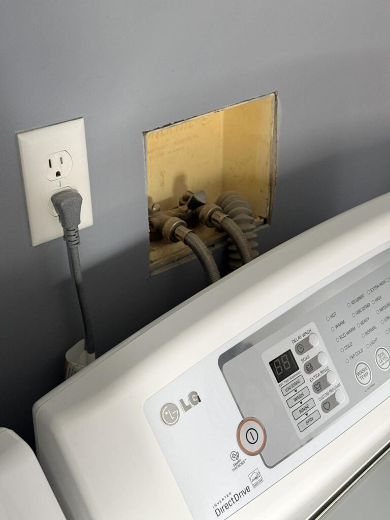 Ugly washer hookups in exposed box in laundry room.