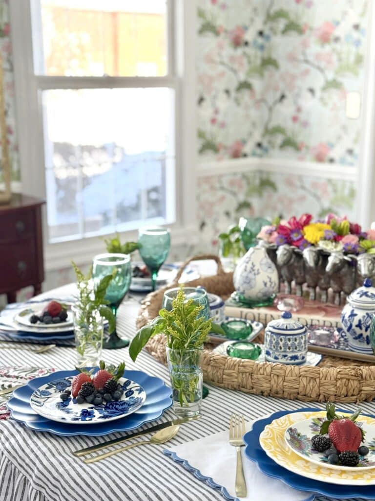 A spring table with herb bouquets, floral centerpiece, layered plates, and floral napkins.