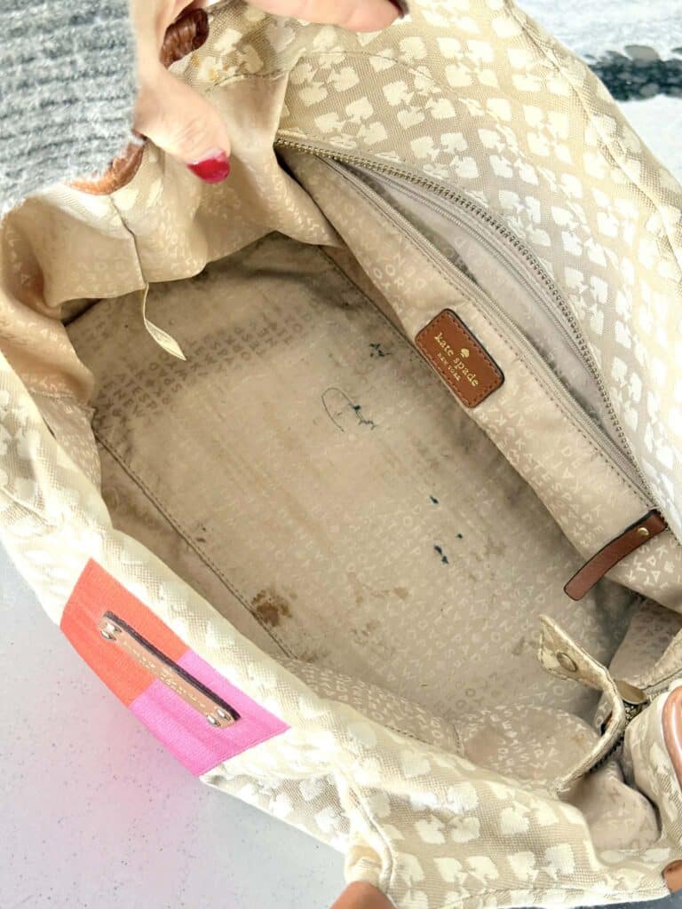 Stains and ink marks on the inside of a canvas bag that needs cleaning.