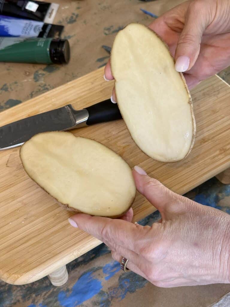 Cutting a potato in half lengthwise.