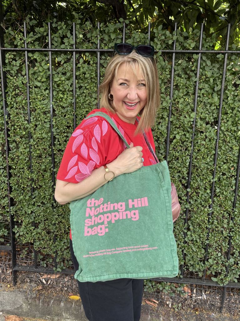 A woman carrying a green canvas tote bag.
