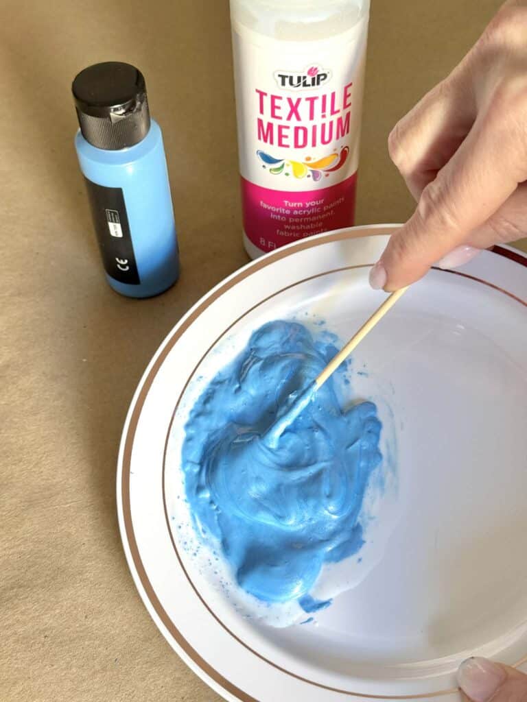 Mixing blue paint with textile medium.