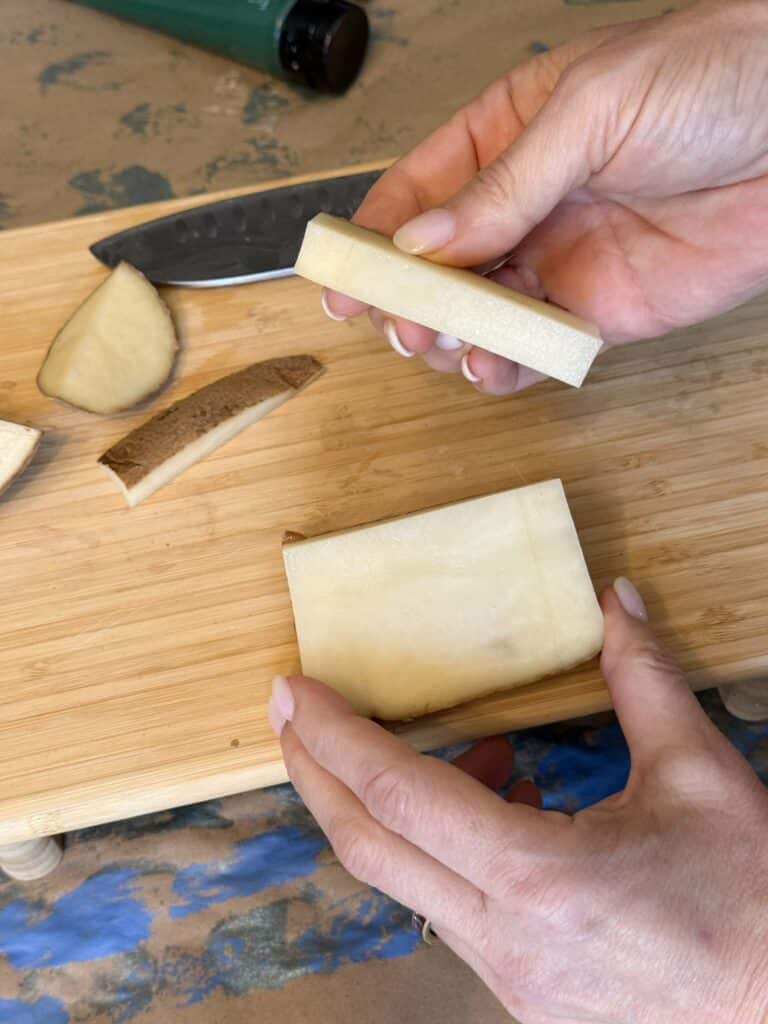 Cutting a rectangular strip from a potato for block printing.