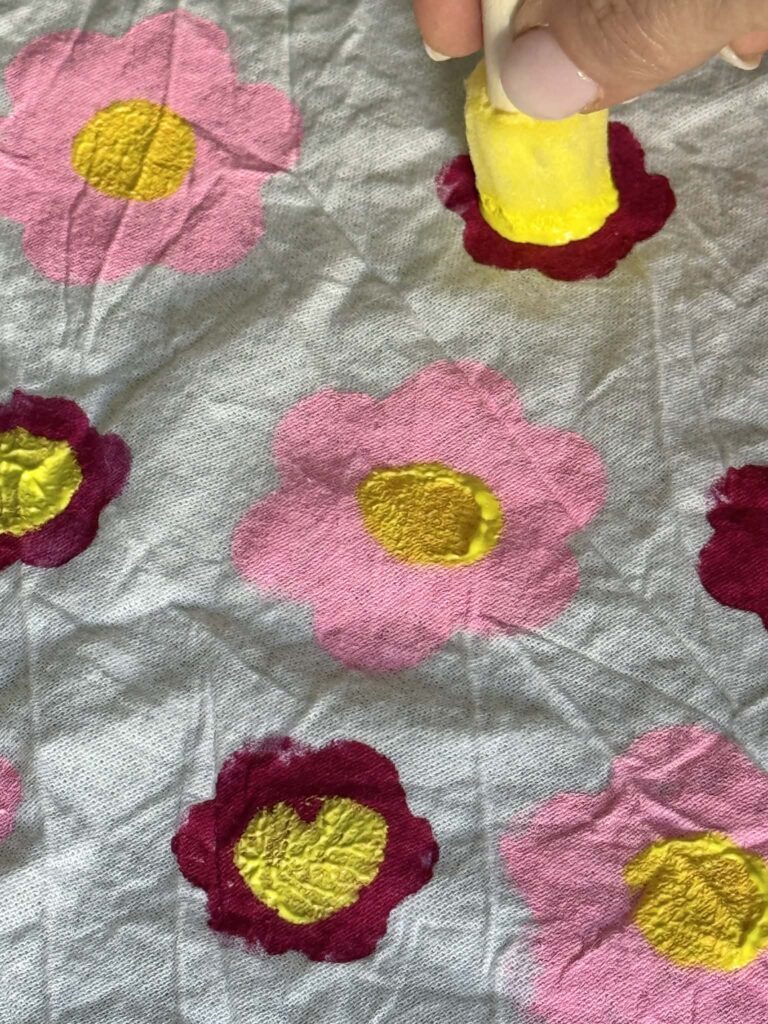 A tea towel with a pink and magenta flower pattern.