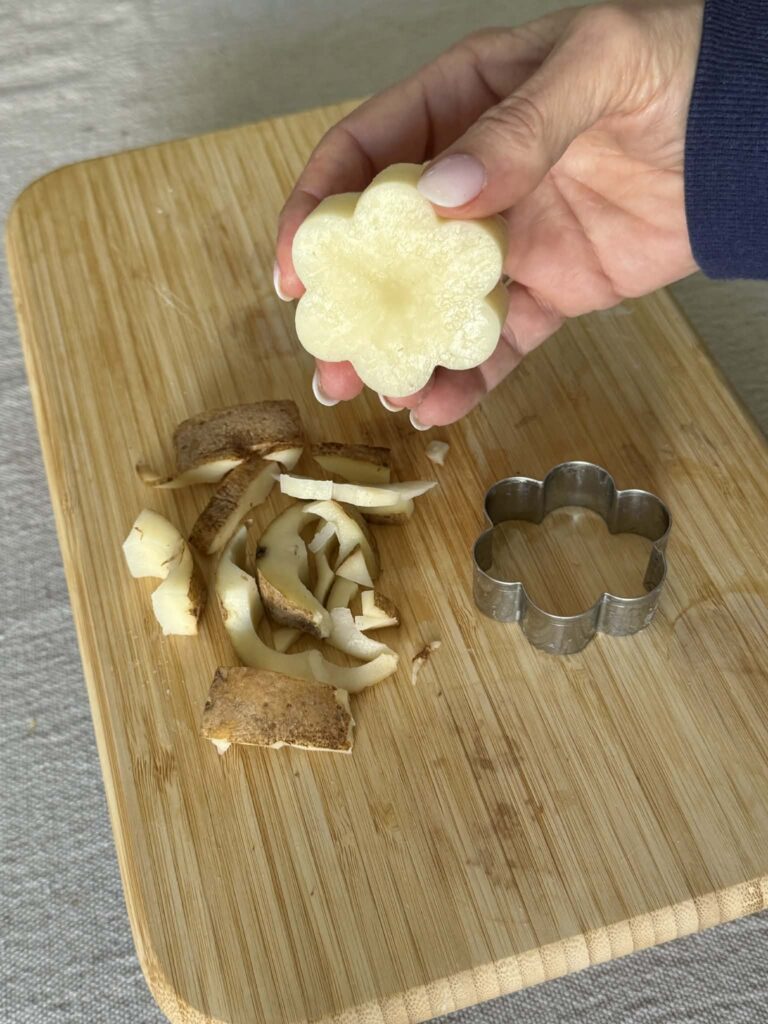 A potato block in the shape of a flower for printing.
