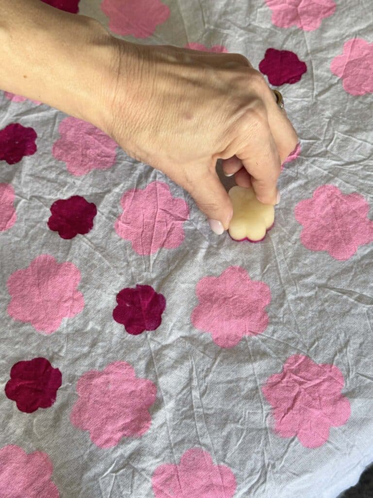 potato printing small flowers onto a tea towel.