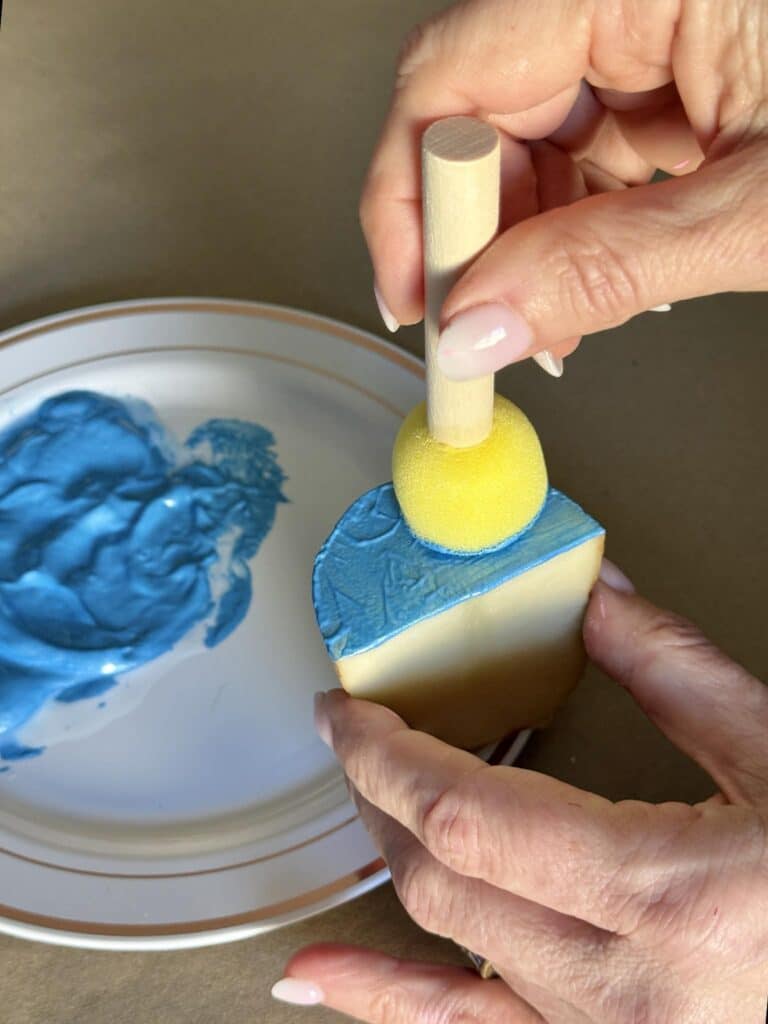 Applying paint to a piece of potato for block printing a pattern.