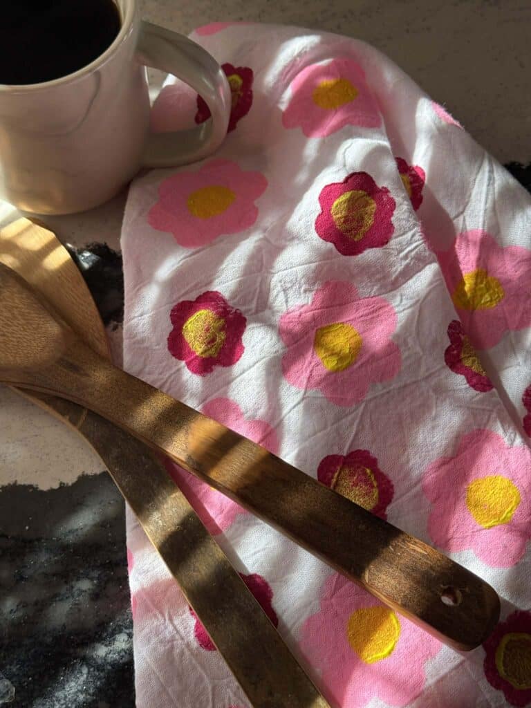 A tea towel with a floral pattern created with a potato block.