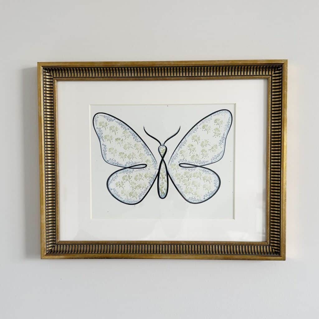 A wall art piece consisting of a butterfly with block print on the inside. Created by White Lilac Farmhouse.