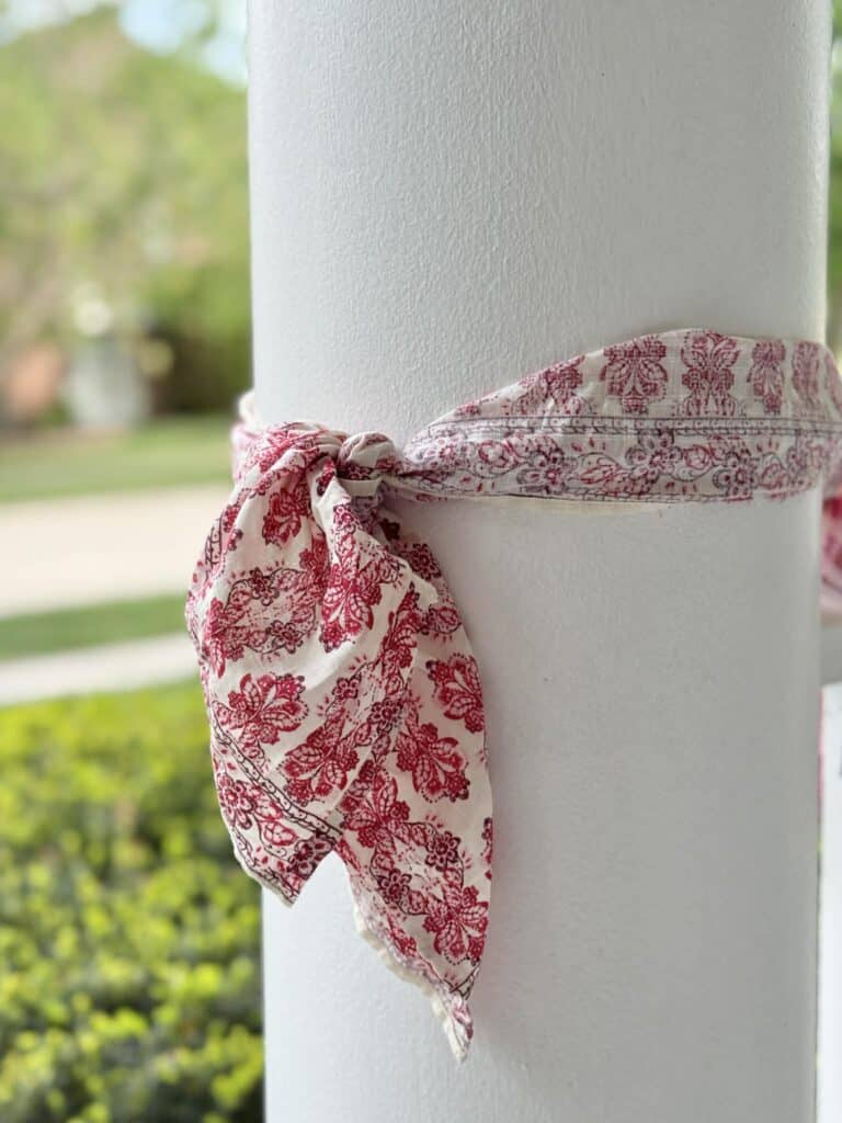 A fabric bow on a porch pillar.