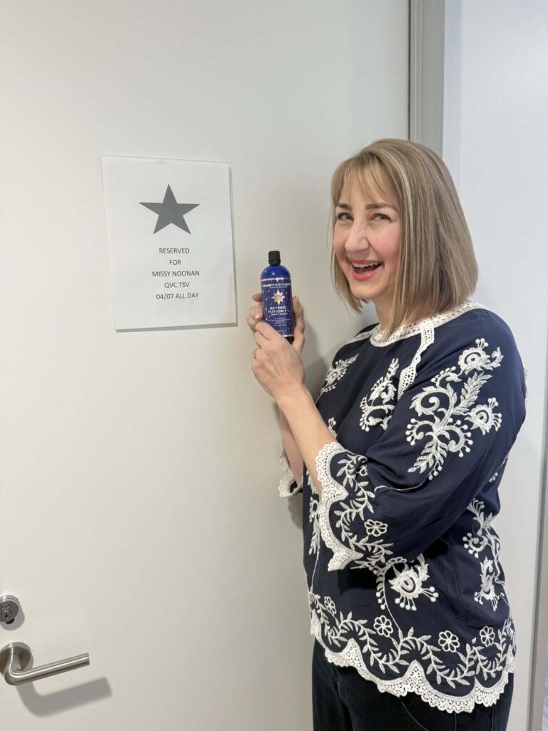 A woman holding a bottle of PTK retinol serum as sold by QVC.