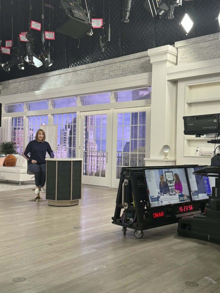 A woman facing the cameras on the QVC set.