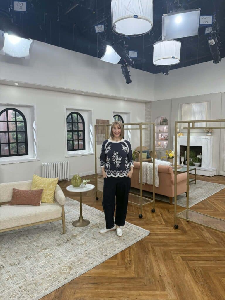 A woman standing on the QVC set.