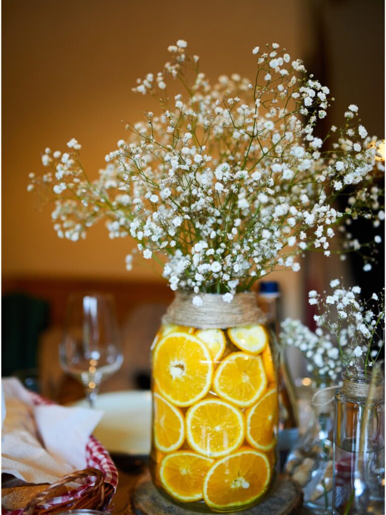 Sliced lemons layered in a mason jar with baby's breath spilling out the top.