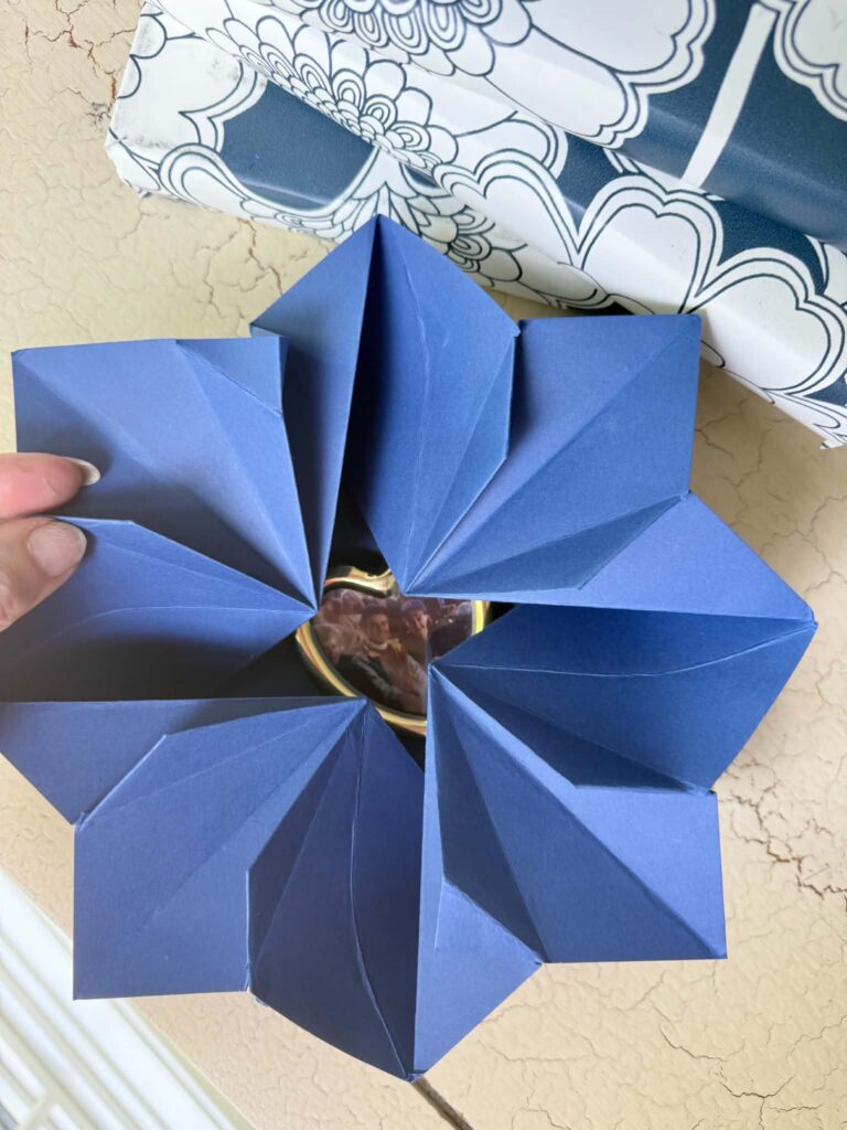 An origami envelope opening up to reveal a small framed photo.