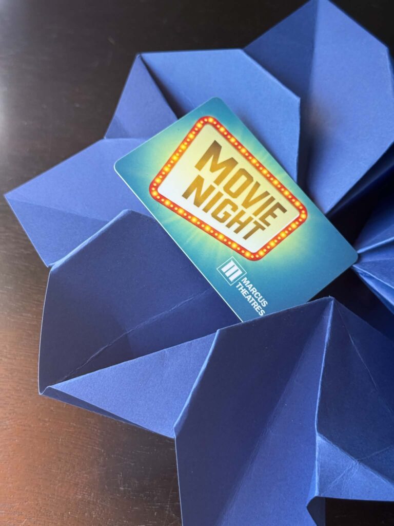 An origami envelope holding a gift card.