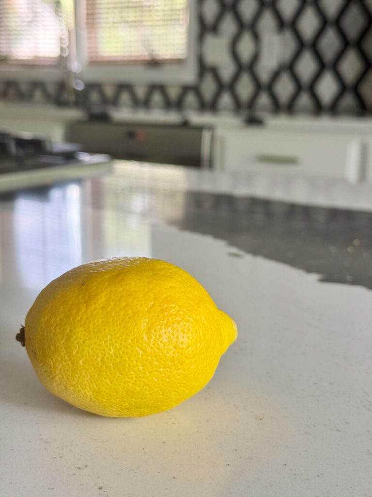 A single lemon on a kitchen counter.