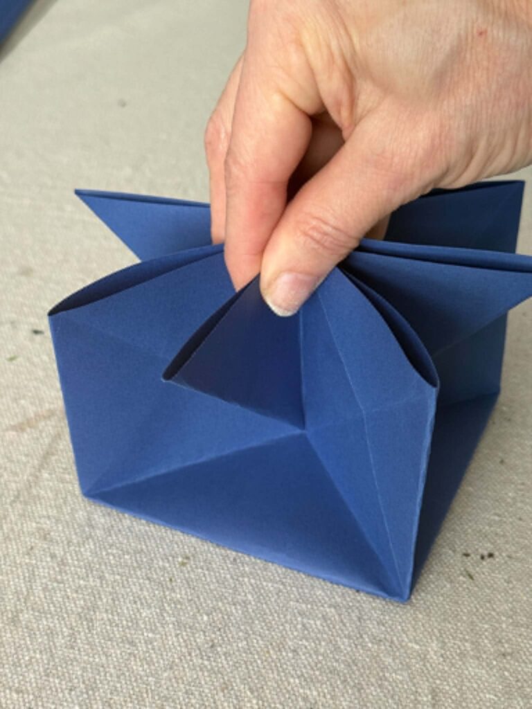 Pinching an inner fold of an origami envelope.