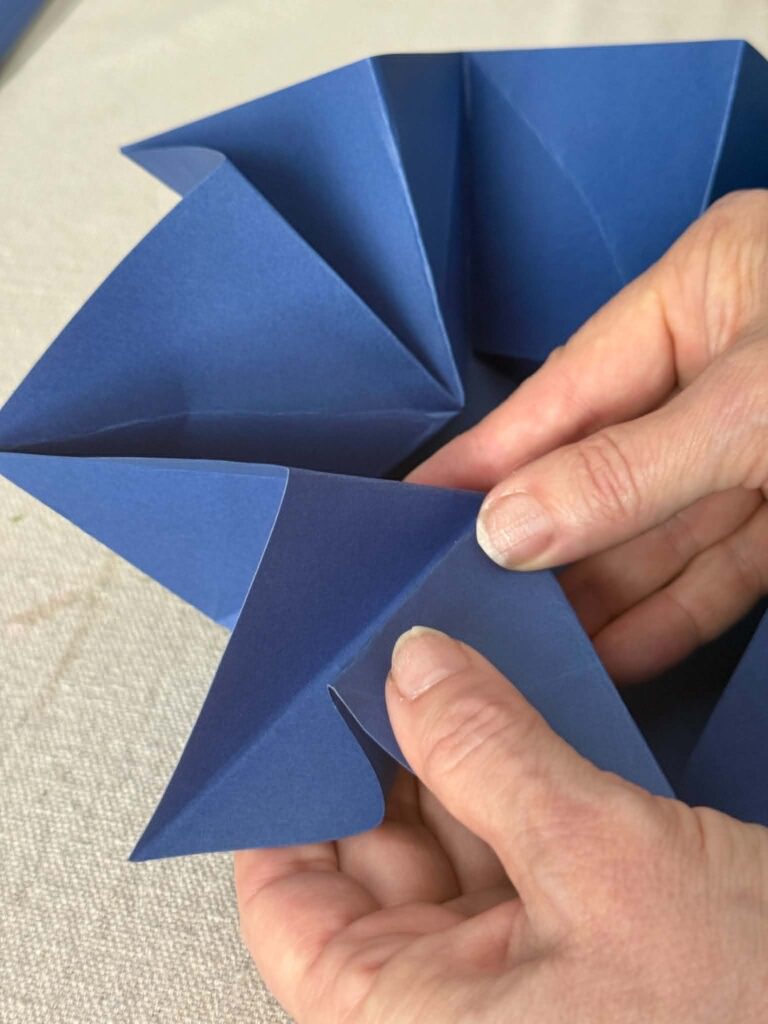 Folding over a pinch fold in an origami envelope.