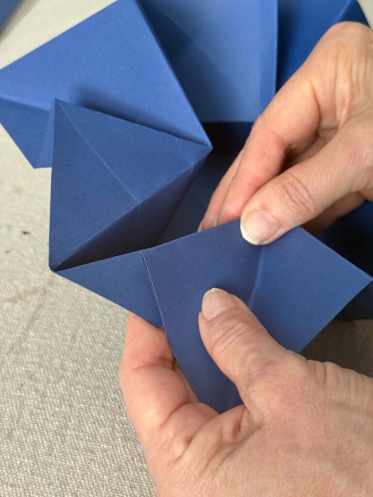 Multiple origami folds to create an envelope to hold a handwritten note.