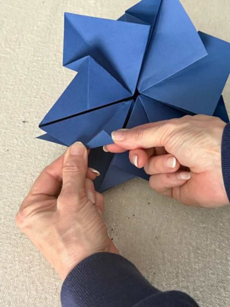 Folding the tips of an origami envelope.