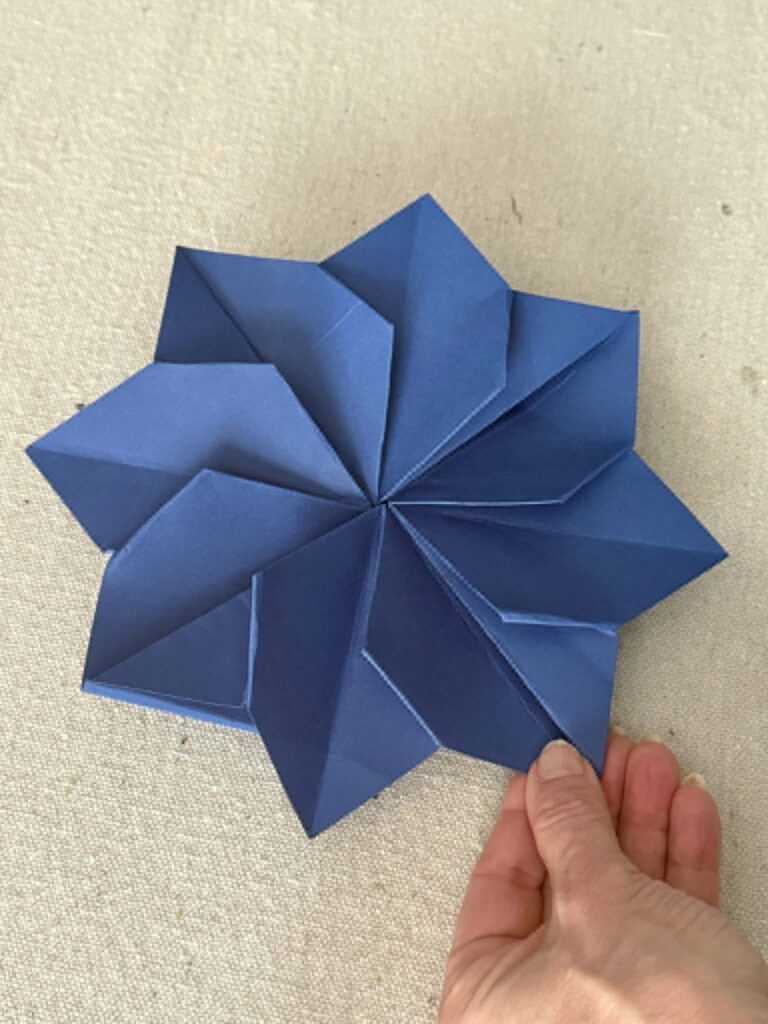 A completed origami envelope in the shape of a flower.
