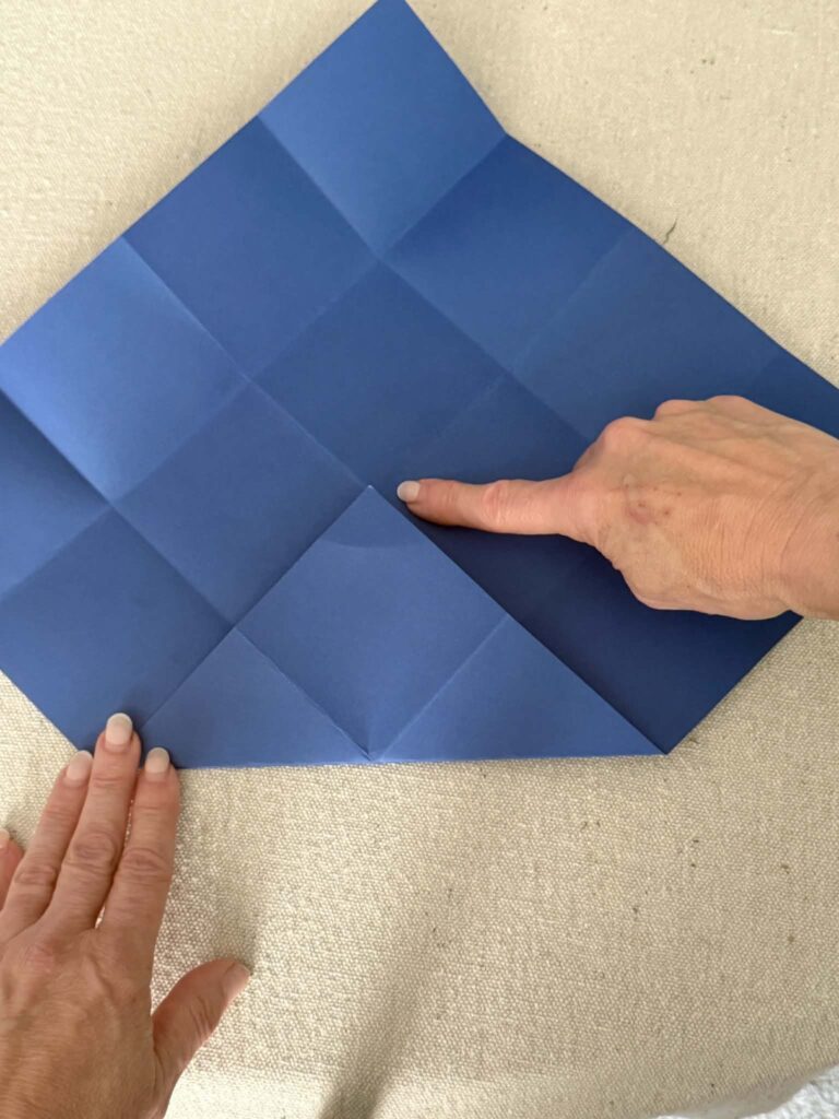 Triangular fold in card stock paper for origami envelope.