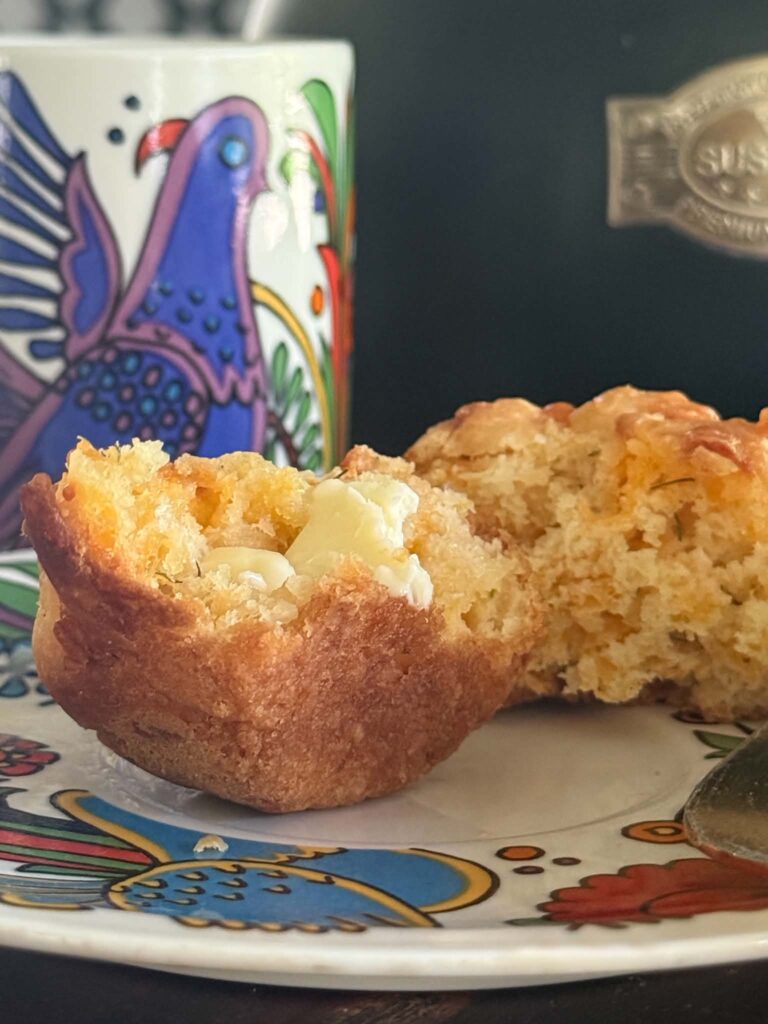 A cheddar dill muffin with butter.