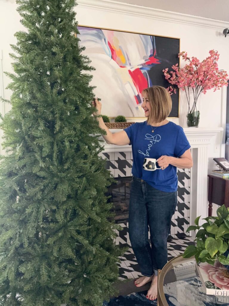 A woman bending the branches of the best slim artificial Christmas tree from King of Christmas.