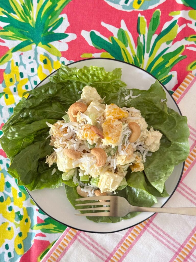 Curry chicken salad plated and sitting on colorful tropical themed linens.