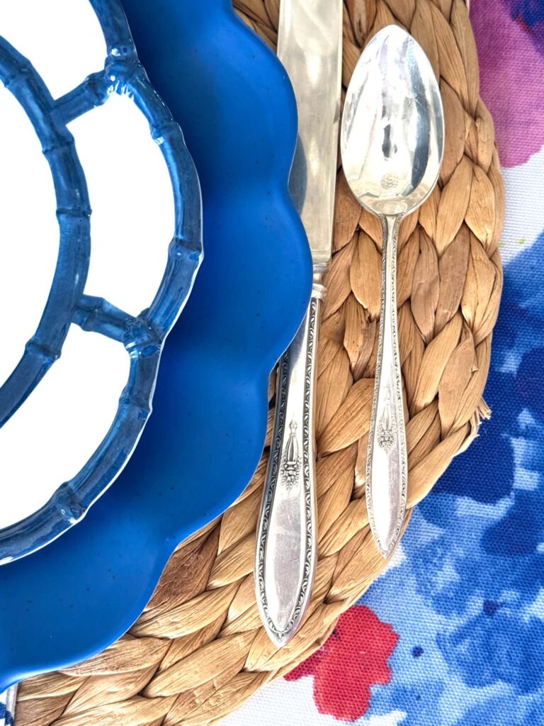 A silver knife and spoon on a woven placemat.