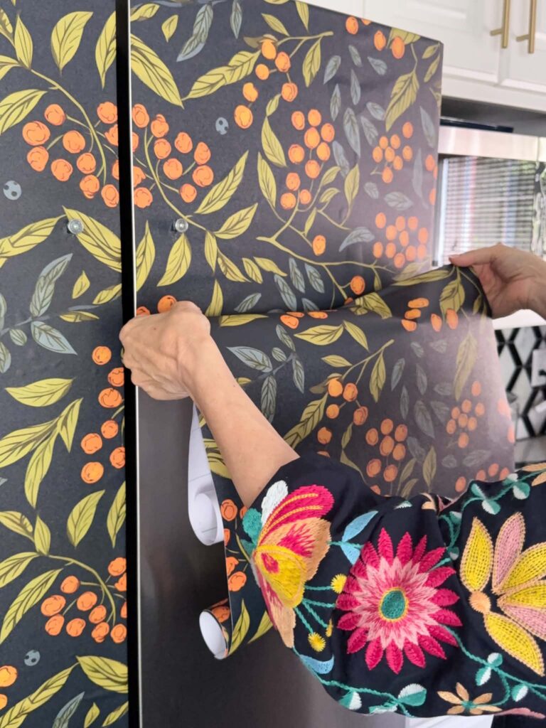 Repositioning peel and stick wallpaper on a refrigerator door.