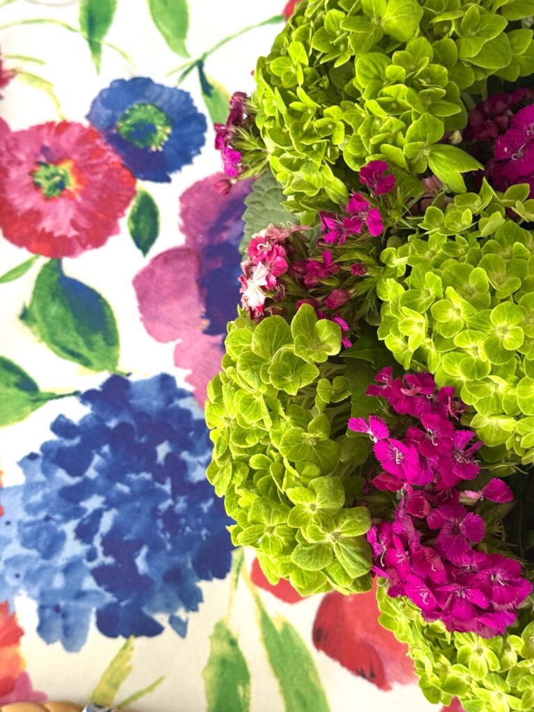 Fresh flowers on a floral summer tablecloth.