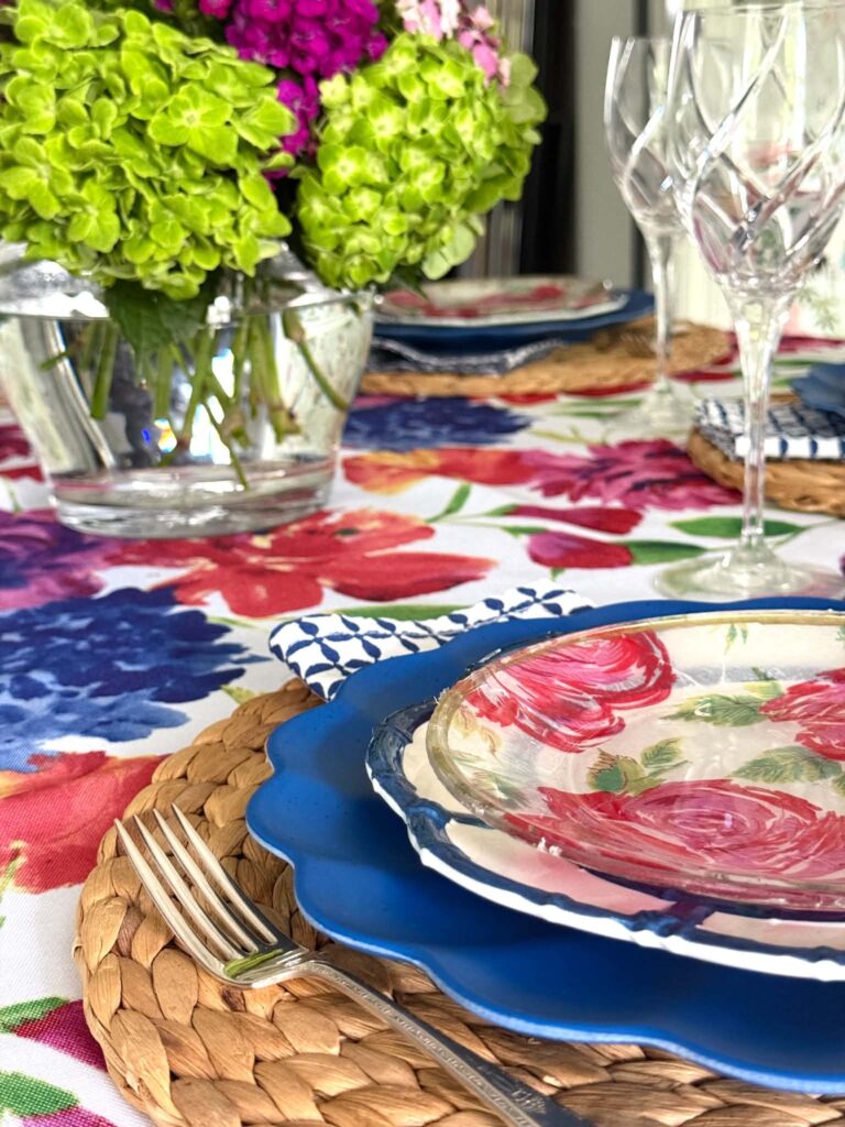 A stack of layered plates on a summer table setting.