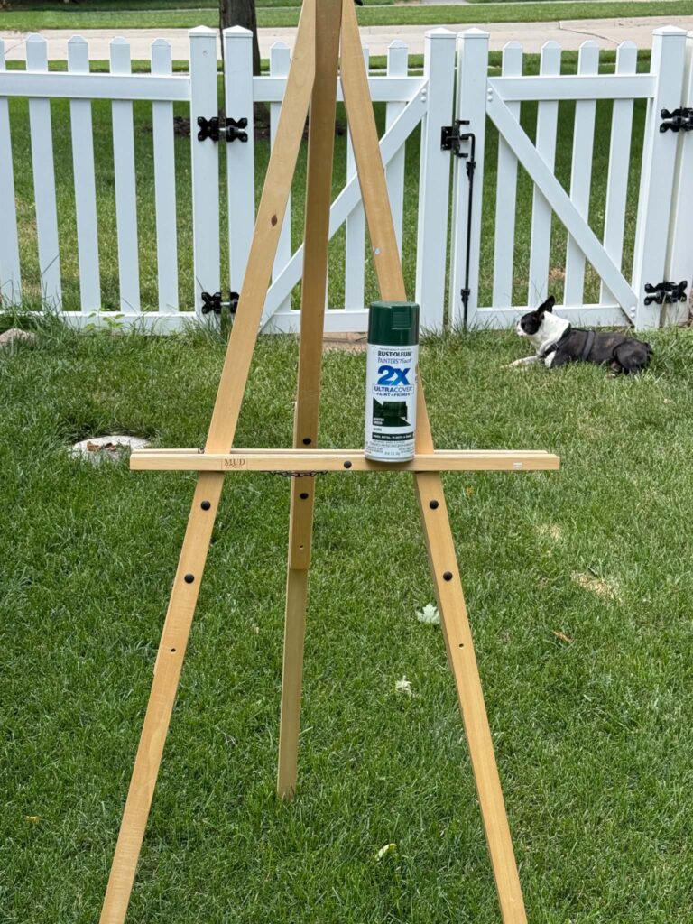 A wooden easel and a can of green spray paint.