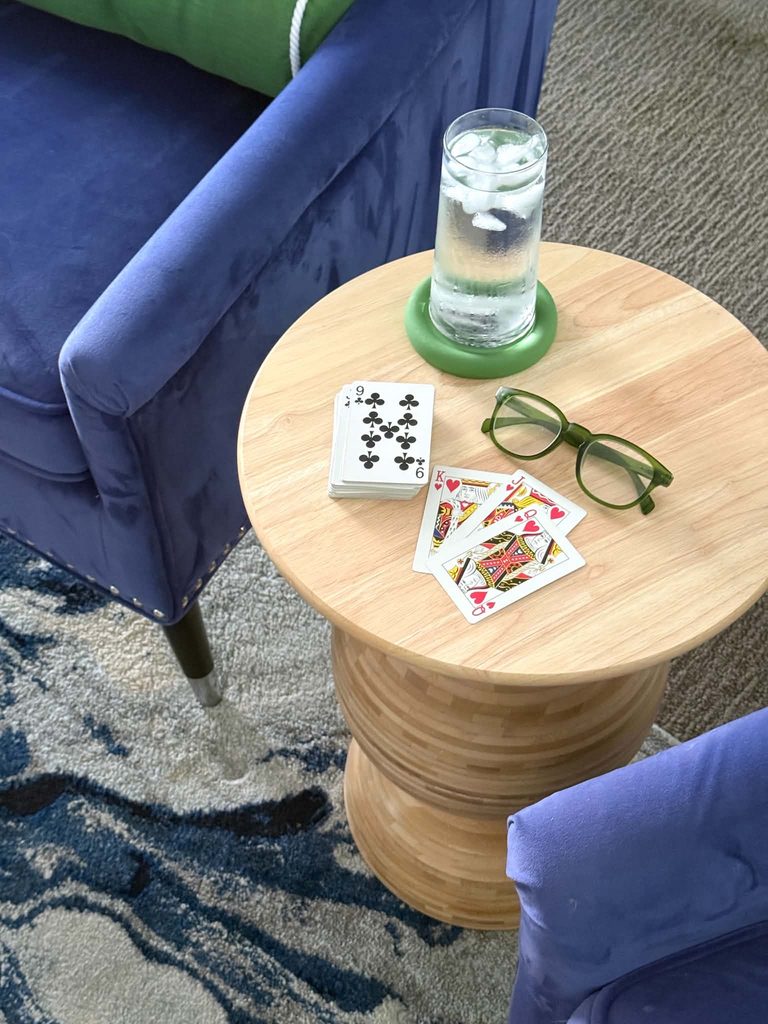 Playing cards. reading glasses, and a glass of water on top of a DIY side table made from IKEA BLANDA MATT wood salad bowls.